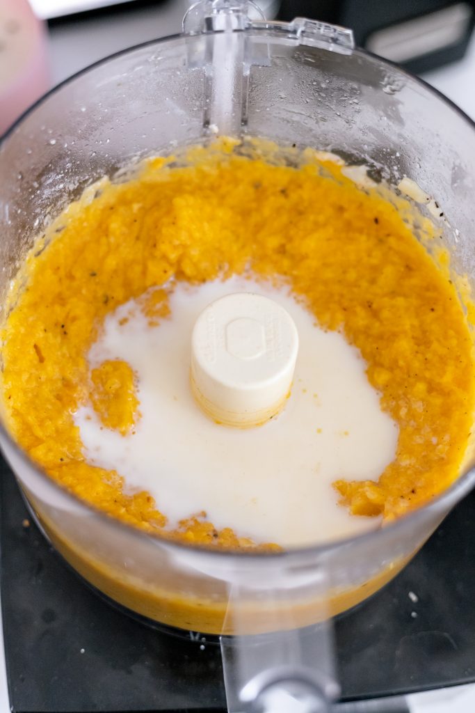 Pureed butternut squash in a food processor with milk (how to make butternut squash macaroni and cheese process shot)