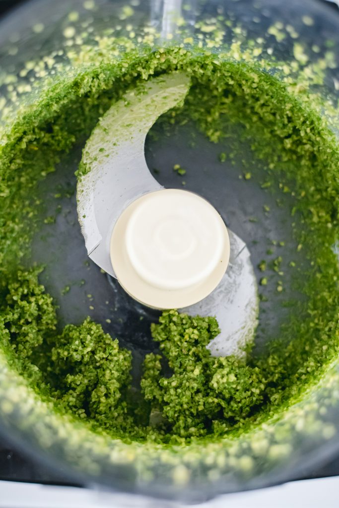 How to make basil pesto: a green paste in a food processor with the blade attachment.