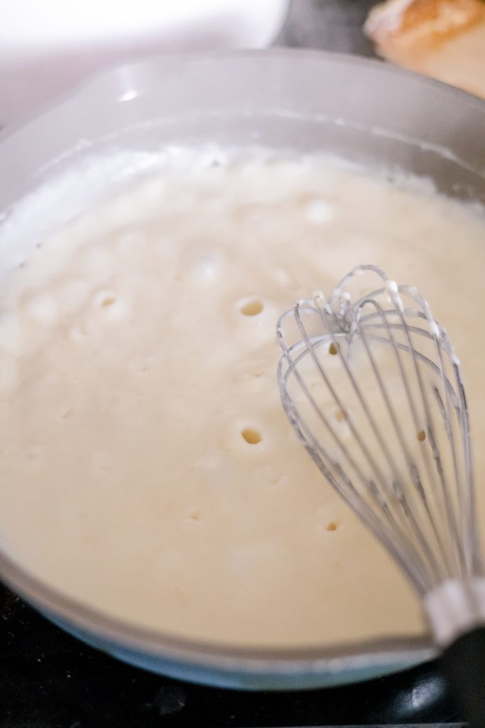 Whisk stirring a roux over the stove (how to make butternut squash macaroni and cheese process shot)