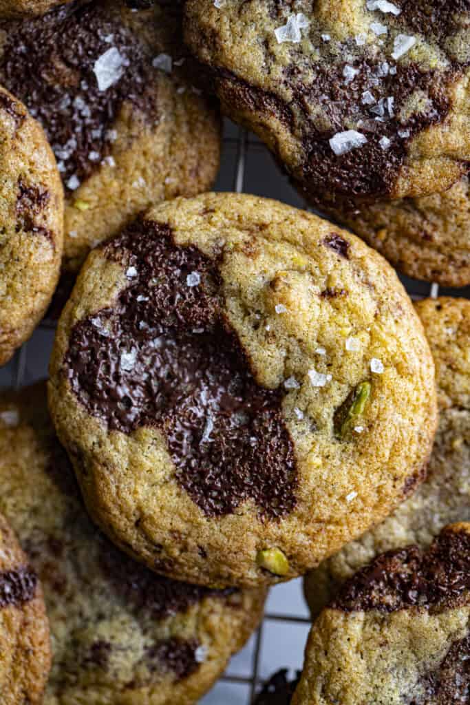 Overhead zoomed in shot of chocolate chunk cookies with pistachios in them.