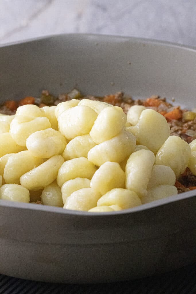 Pillowy potato gnocchi added to bolognese sauce.