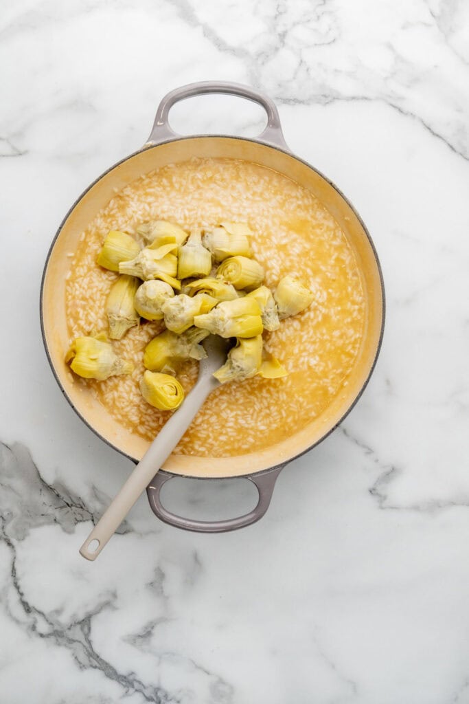 Cooking artichoke risotto.