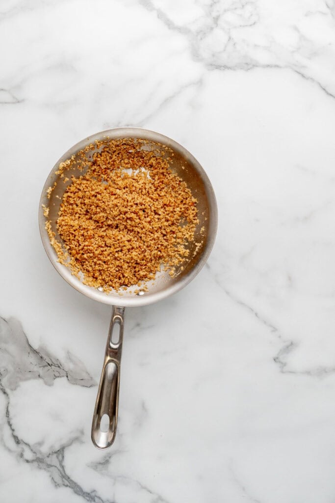 Cooking breadcrumbs for a baked bolognese dish.
