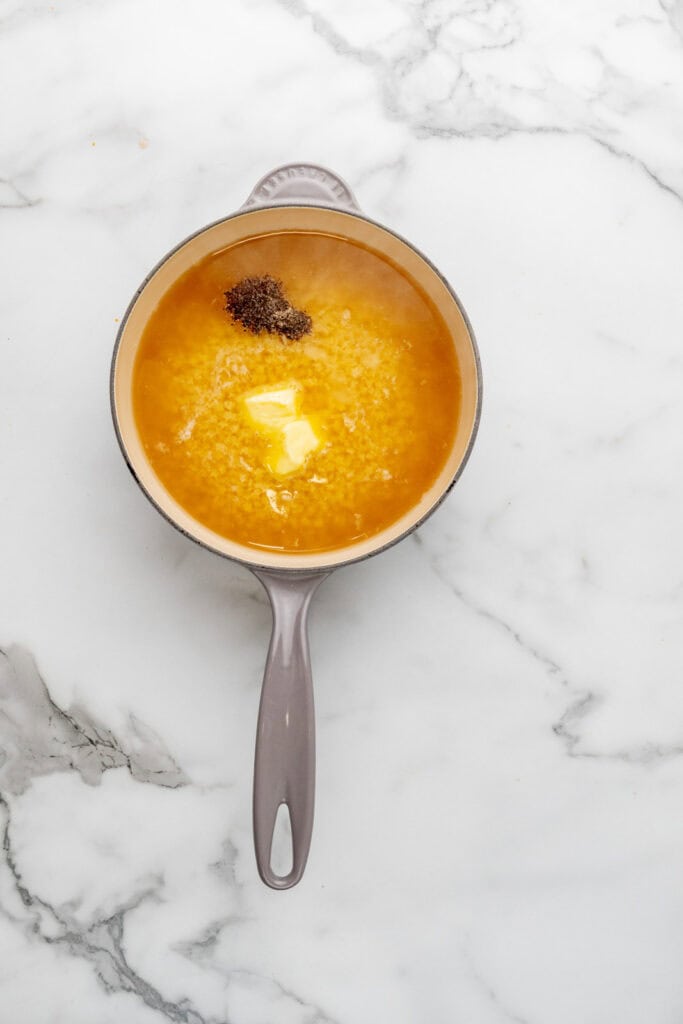 Cooking pasta in chicken stock for an easy pastina recipe.