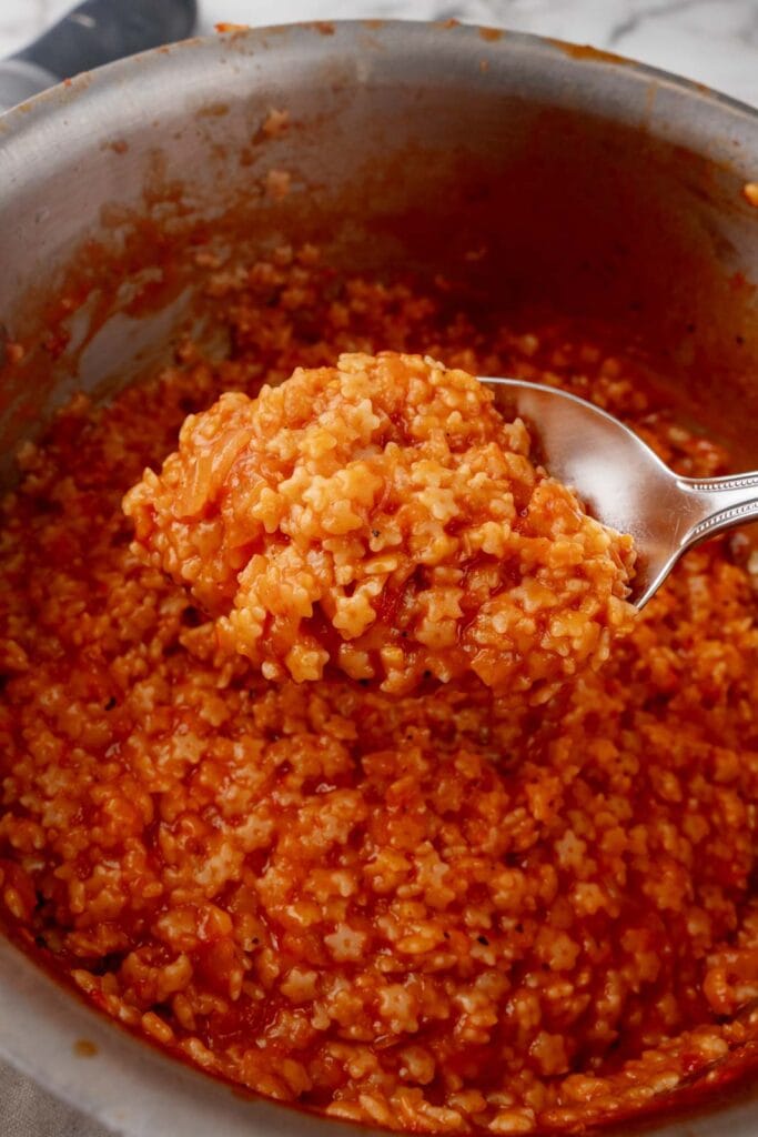 Creamy tomato pastina in a pot being served.
