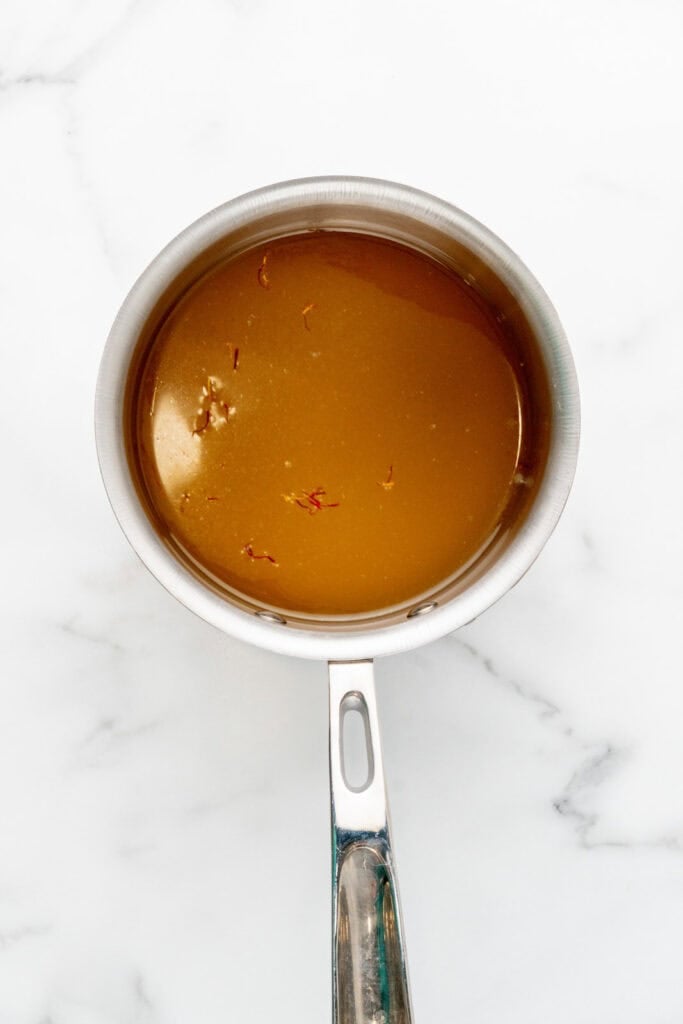 Blooming saffron in chicken stock to make risotto milanese.