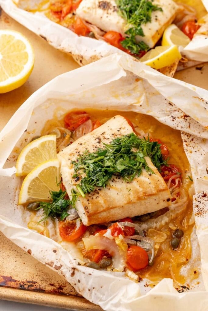 Halibut in parchment paper with veggies and herbs.