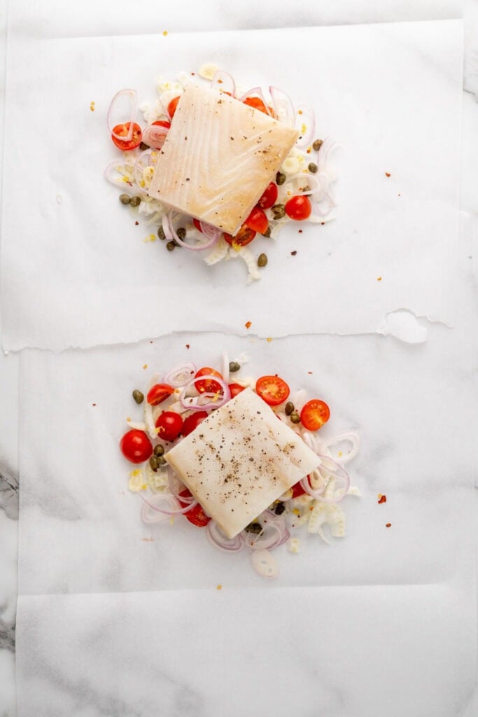 Halibut with veggies on parchment paper.