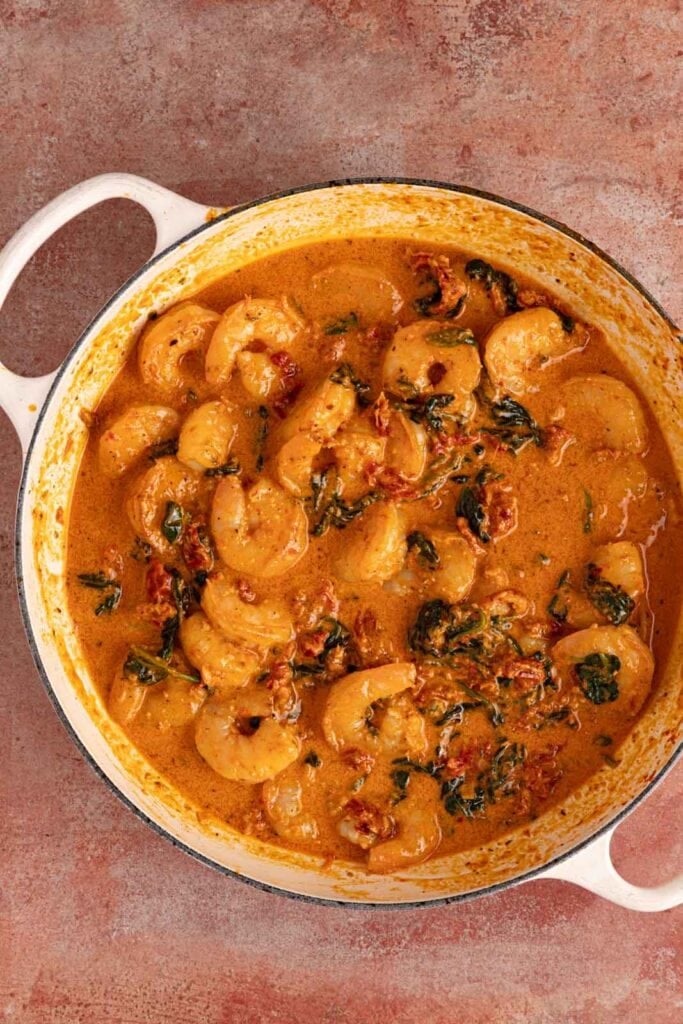 Creamy tuscan shrimp in a pan.