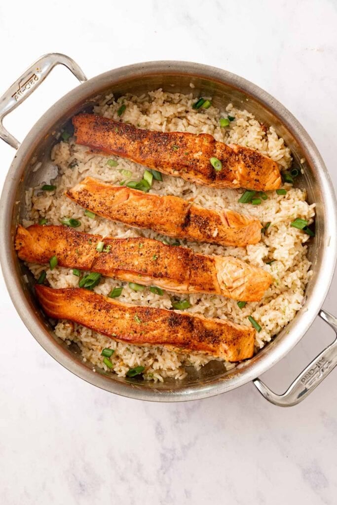 Salmon and rice in a pot with scallions.