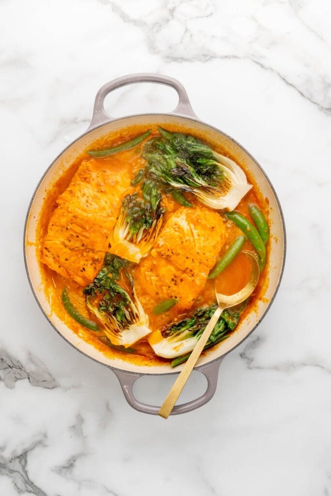 Making a red coconut curry with salmon and veggies.