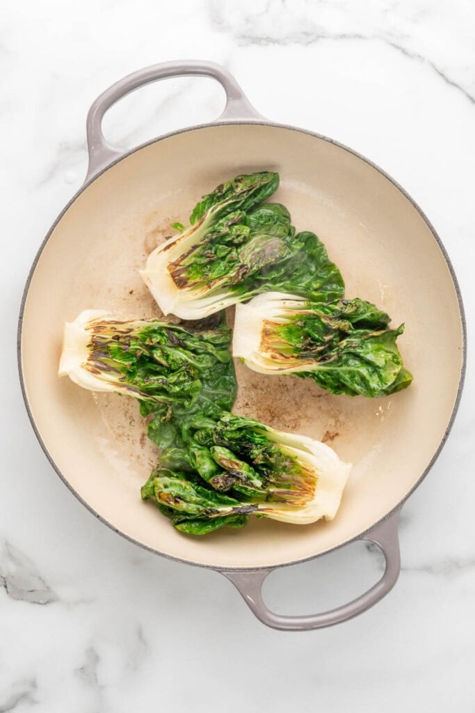 Searing bok choy in a pan.