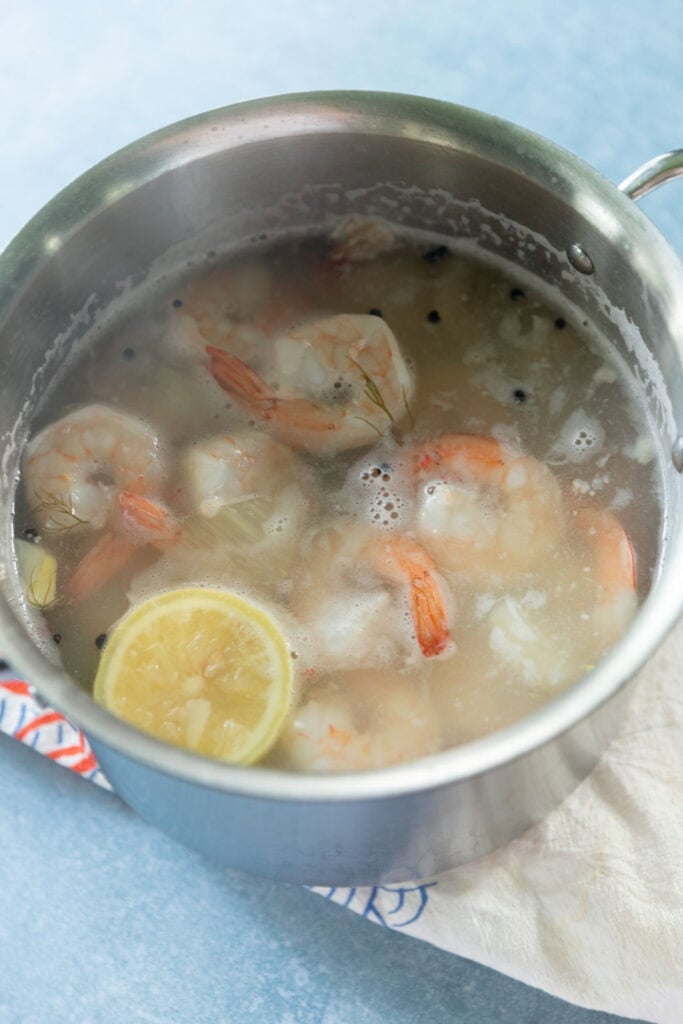 Poaching shrimp with lemon and aromatics.