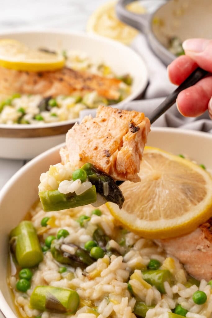 A fork bite of risotto and salmon.