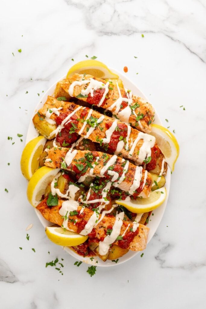Salmon with potatoes and patatas bravas sauce and aioli.