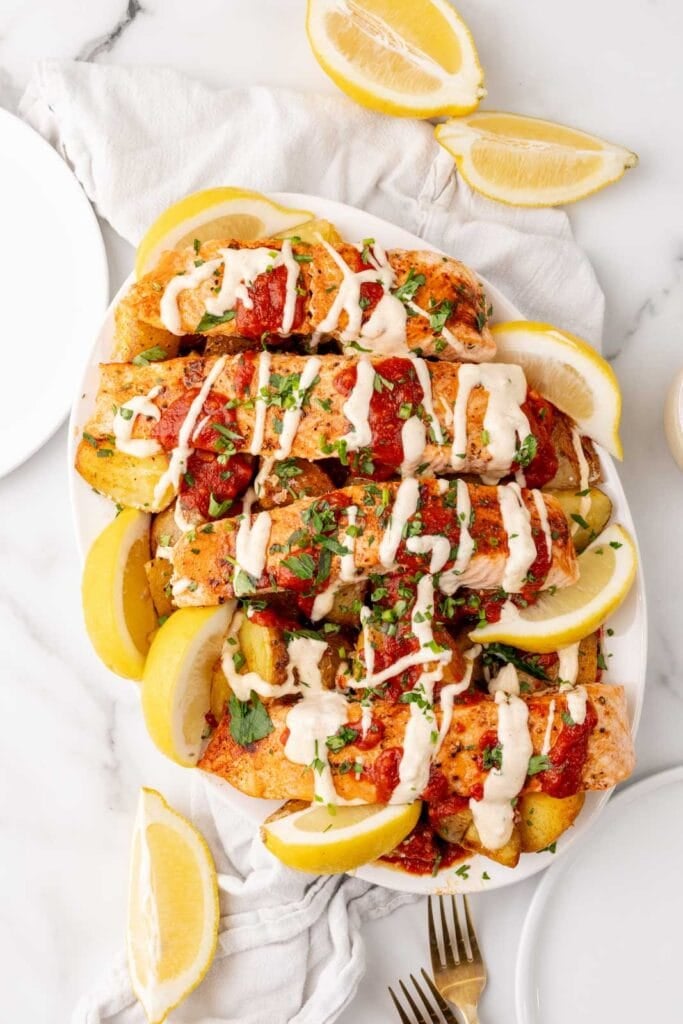 Salmon with potatoes and patatas bravas sauce and aioli.