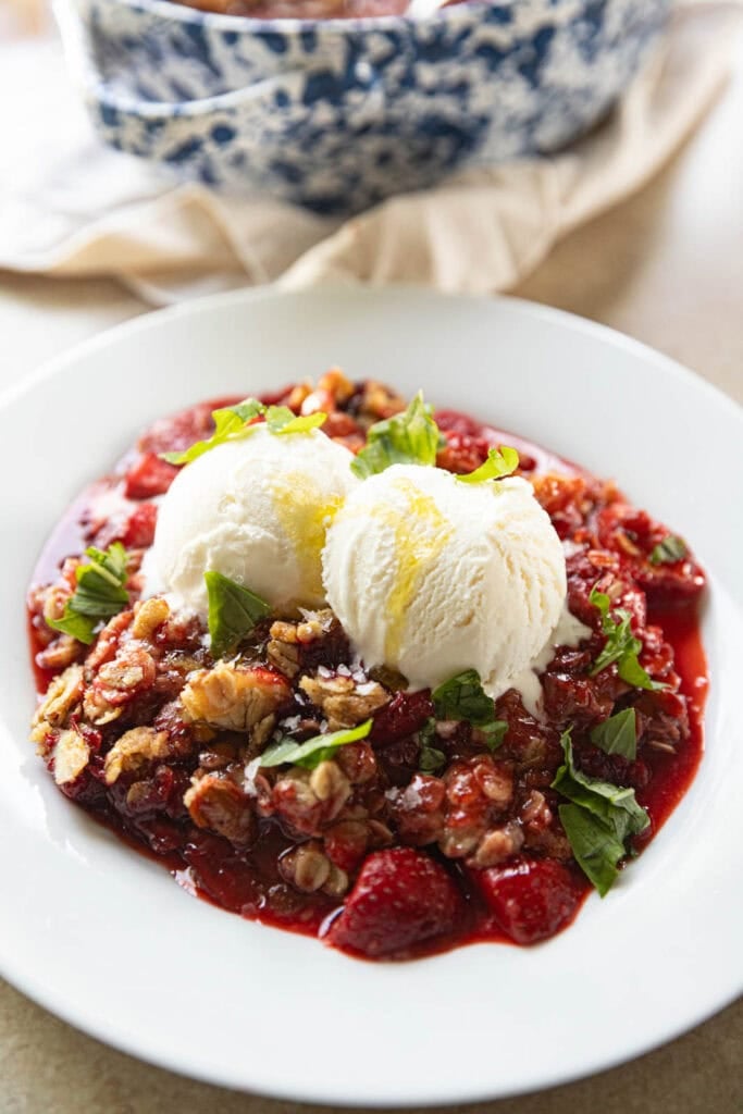 A strawberry crumble with vanilla ice cream, basil.