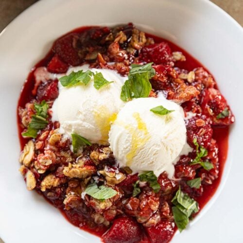 A strawberry crumble with vanilla ice cream, basil.