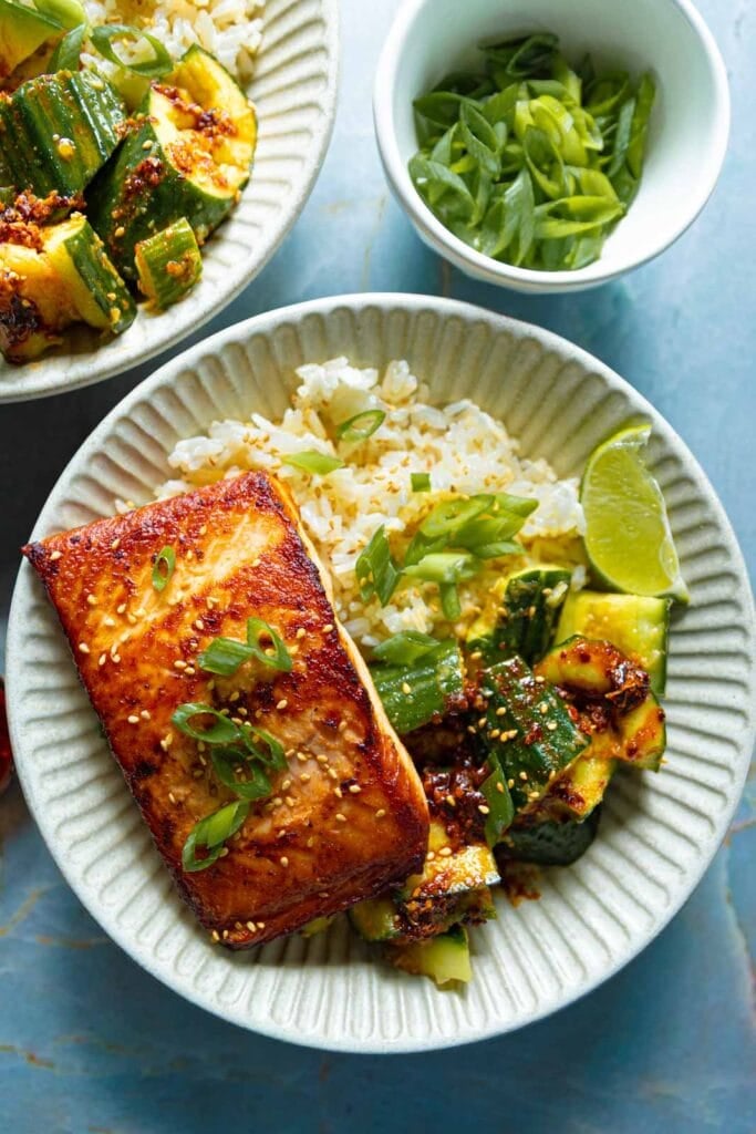 Asian style salmon and cucumber salad with rice in a bowl.