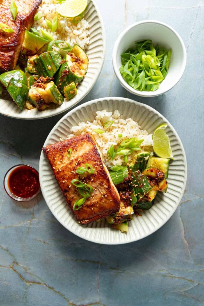 Asian style salmon and cucumber salad with rice in a bowl.